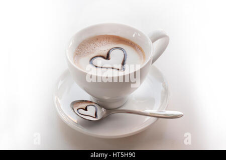 Invitant les tasse de Cappuccino avec coeur choccolate sur haut et dans la cuillère ci-dessous Banque D'Images