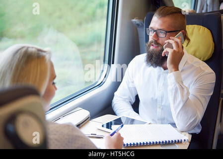 Les gens d'affaires occupés dans le train Banque D'Images