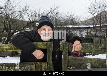 Portrait de plein air ukrainien positive d'un vieil homme qui se tient à sa clôture en milieu rural village ukrainien Banque D'Images