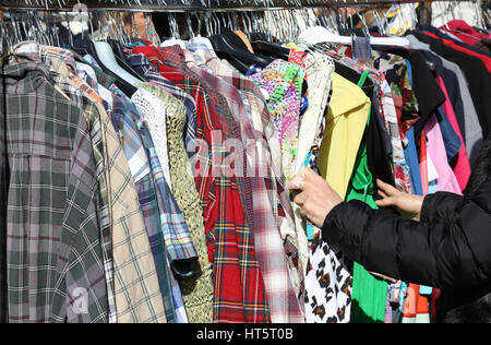 Main de la femme qui achète des vêtements au marché Banque D'Images