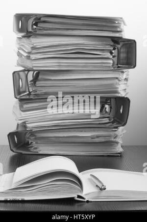 Sept cinq dossiers avec documents empilés dans une pile sur la table. Photo en noir et blanc Banque D'Images