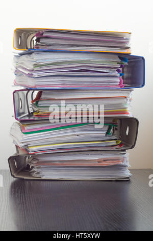 Cinq dossiers avec documents empilés dans une pile sur la table. Fond blanc Banque D'Images