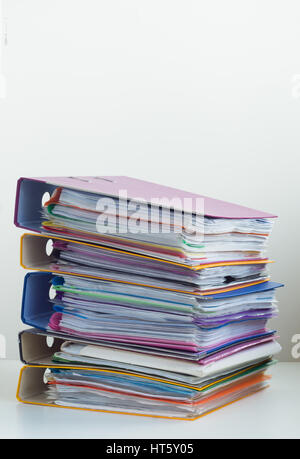 Cinq dossiers avec documents empilés dans une pile sur la table. Fond blanc Banque D'Images