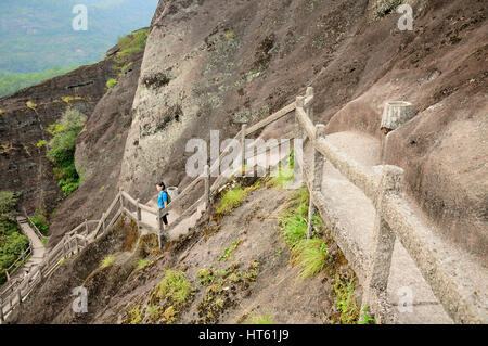 Une femme chinoise qui repose sur les marches de pierre jusqu'au sommet du mont Wuyi Scenic Area dans la province du Fujian en Chine. Banque D'Images