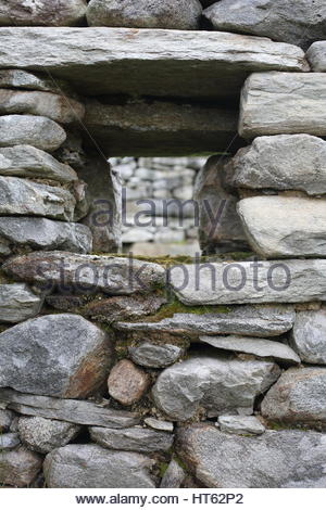 Dans la fenêtre en pierre reains d'une maison en pierre dans un village abandonné sur l'île d'Achill, Comté de Mayo, Irlande Banque D'Images