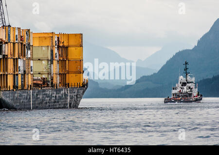 Sur l'image, un remorqueur tire en direction d'une barge chargée de conteneurs le long du détroit de Johnstone, une partie de la Colombie-Britannique est le passage de l'intérieur. Banque D'Images