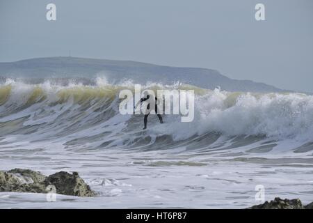 En surfant à Freshwater Bay, île de Wight avec des rochers en premier plan Banque D'Images