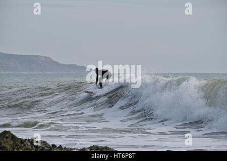 En surfant à Freshwater Bay, île de Wight avec des rochers en premier plan Banque D'Images