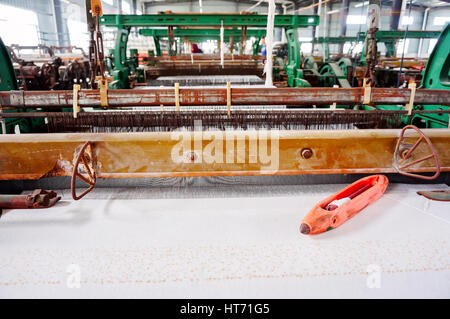 Une rangée de métiers textiles tissage de fils de coton dans une usine de textile Banque D'Images