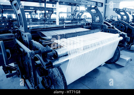 Une rangée de métiers textiles tissage de fils de coton dans une usine de textile Banque D'Images