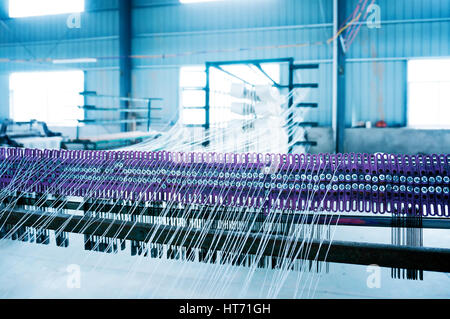 Une rangée de métiers textiles tissage de fils de coton dans une usine de textile Banque D'Images