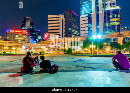 BANGKOK, THAÏLANDE - le 02 février : c'est une vue de nuit de Silom financial district à l'extérieur de l'entrée du Parc Lumphini avec des gens assis et relaxi Banque D'Images
