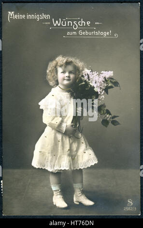 Une carte postale de voeux imprimé en Suisse, montre une fille avec un bouquet de lilas. L'inscription en allemand : Joyeux anniversaire Banque D'Images