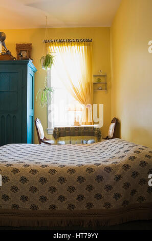 Chambre de maître avec couvre-lit à motifs floraux en 1904 ancienne maison victorienne de l'intérieur. Banque D'Images