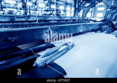 Une rangée de métiers textiles tissage de fils de coton dans une usine de textile Banque D'Images