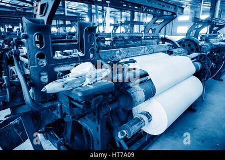 Une rangée de métiers textiles tissage de fils de coton dans une usine de textile Banque D'Images