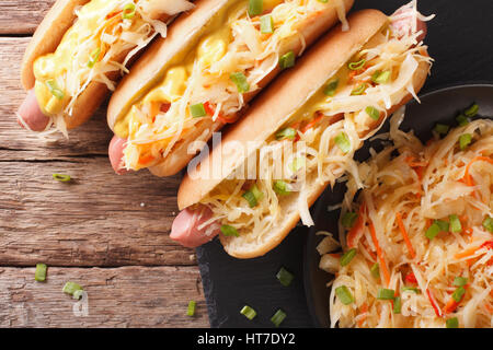 Sandwich avec saucisses, choucroute et moutarde close up sur la table. vue horizontale d'en haut Banque D'Images