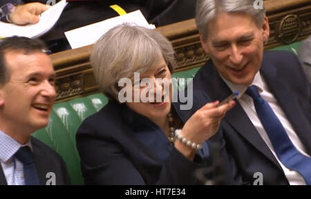 Premier ministre Theresa peut rire avec Secrétaire Gallois Alun Cairns (à gauche) et le Chancelier Philip Hammond lors de questions au premier ministre à la Chambre des communes, Londres. Banque D'Images