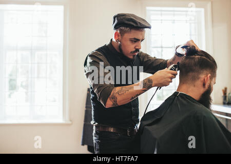 La coupe de cheveux coiffeur de client à un coiffeur. L'homme se coupe au salon de coiffure. Banque D'Images
