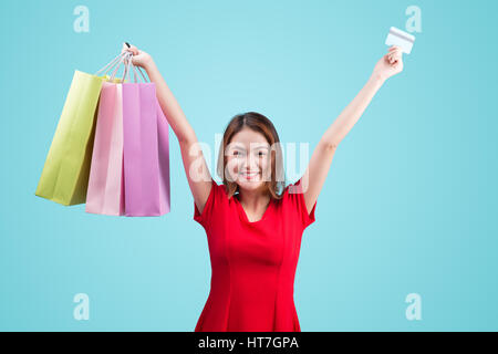 Santa asian woman holding shopping bags, une carte de crédit contre la vignette bleue Banque D'Images