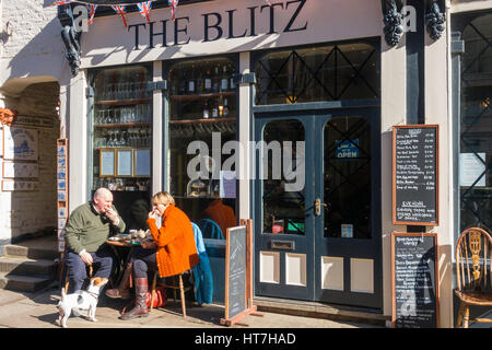 Un couple avec un Jack Russell chien appréciant le déjeuner au soleil du printemps au Blitz café Whitby North Yorkshire Angleterre Banque D'Images