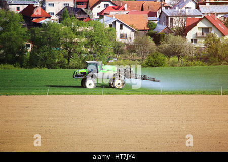 Le tracteur au champ des agriculteurs. Travaux agricoles sur le terrain. au printemps Bright fond agricole. Banque D'Images