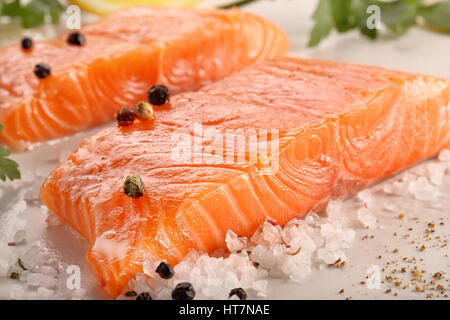Le saumon frais avec des herbes et épices prêt pour la cuisson sur fond de pierre Banque D'Images