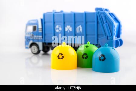 Poubelles couleur camion poubelle et jouets sur fond blanc Banque D'Images