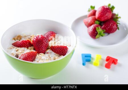 Close up de l'assiette de fruits avec du yaourt fait maison, fraises, sur fond blanc Banque D'Images