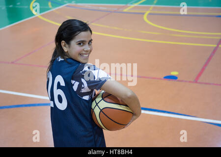 Girl with ball dans la cour de basket-ball Banque D'Images