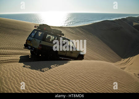 Un vehilce en réduisant la friction raide des dunes face au bord de la mer, dans le désert du Namib Banque D'Images