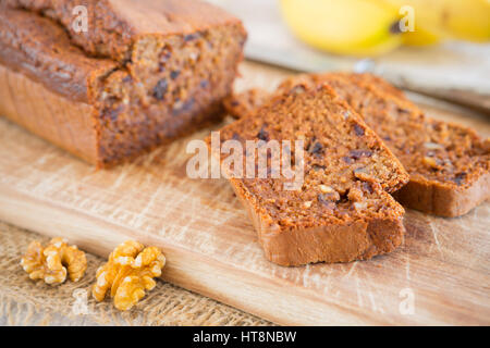 Pain aux bananes maison avec des noix et des dates sur une table rustique. Banque D'Images