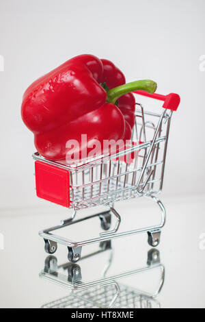 Mini panier shopping trolley, légumes frais biologiques de sorcière, l'un venu pepeer sur fond clair. . Concept de l'alimentation saine, les régimes végétariens shopping, cuisine Banque D'Images