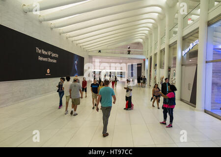 Les gens qui marchent le long de grands panneaux d'affichage LED de la publicité à l'Oculus WTC centre de transports de hall de l'ouest de la ville de New York Banque D'Images