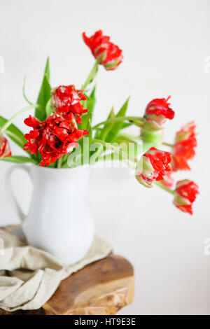 Nature morte au bouquet de tulipes dans un vase blanc en bois chaise rustique sur Banque D'Images