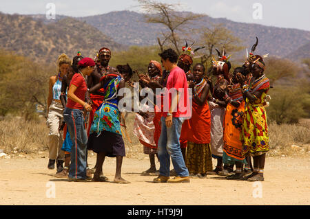 Les guerriers Samburu danse avec les touristes dans un près de manyatta Archers Post, Samburu National Park, Kenya Banque D'Images