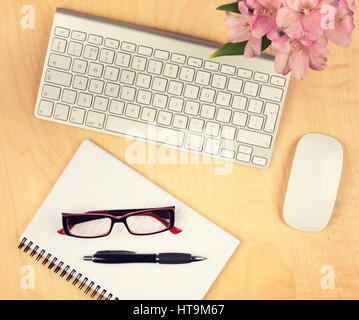 Table de bureau avec le bloc-notes, ordinateur et lunettes de lecture. Vue du dessus avec copie espace. Banque D'Images