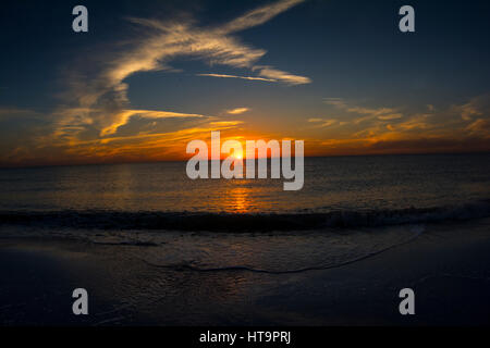 Belle plage coucher de soleil avec des vagues et de couleur vive skies Banque D'Images