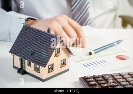 Businessman calculer le coût de construction et d'entretien de maison. Accueil finances conception Banque D'Images