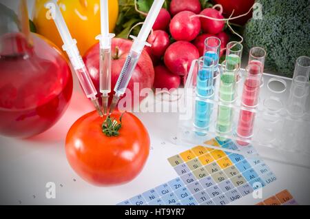 Trois seringues en rouge tomate. Les aliments génétiquement modifiés dans lab concept. Banque D'Images