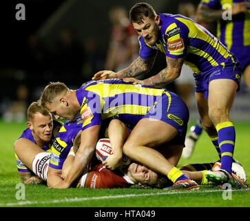 Wigan Warriors' George Williams est plaqué juste avant la ligne par Warrington Wolves' Joe Westerman, Kevin Brown (à gauche) et Daryl Clark (à droite), au cours de la Super League Betfred match au stade Halliwell Jones, Warrington. Banque D'Images