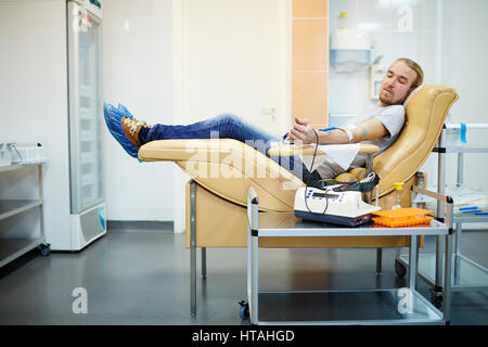 Jeune bénévole faisant don de son sang en hemotransfusion gare Banque D'Images