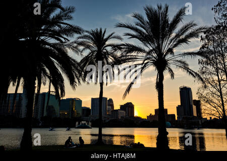 Vue sur l'horizon sur le lac Eola et palmiers au coucher du soleil à Orlando, Floride. Lake Eola Park est situé au cœur du centre-ville d'Orlando et d'accueil à l'Amphithéâtre de Walt Disney. Banque D'Images