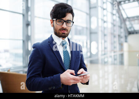 Les jeunes en fonction de l'employeur et les lunettes looking at camera Banque D'Images