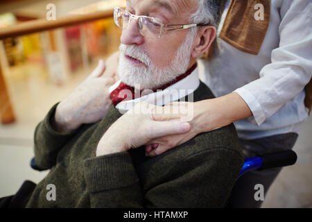 Mobilité senior man holding sa femme mains Banque D'Images