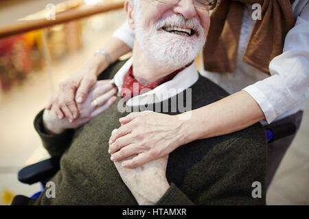 Happy senior man in wheelchair holding female hands Banque D'Images