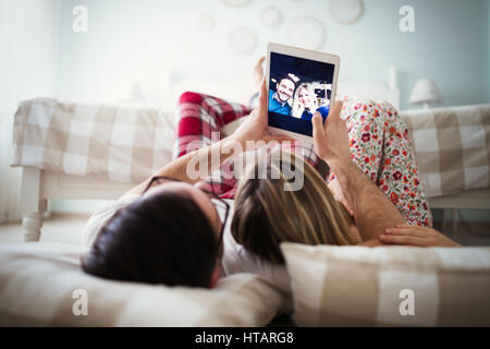 Couple aimant prendre des autoportraits à la maison en pyjama. Banque D'Images