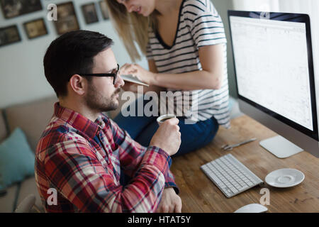 L'homme créatif travaillant à la maison avec ma femme alors que la consommation de café Banque D'Images