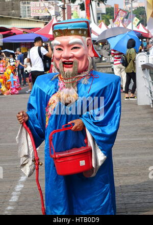 KAOHSIUNG, TAIWAN -- 17 octobre 2015 : un homme habillé en chinois traditionnel le Dieu de la richesse nous amène à Lucky Charm de dons. Banque D'Images