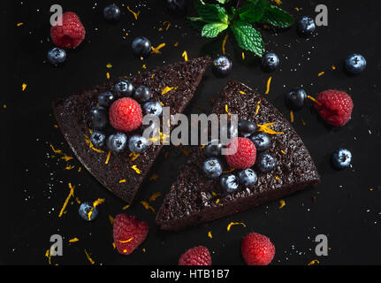 Gâteau au chocolat avec des framboises, bleuets, le zeste d'orange et pipermint Banque D'Images